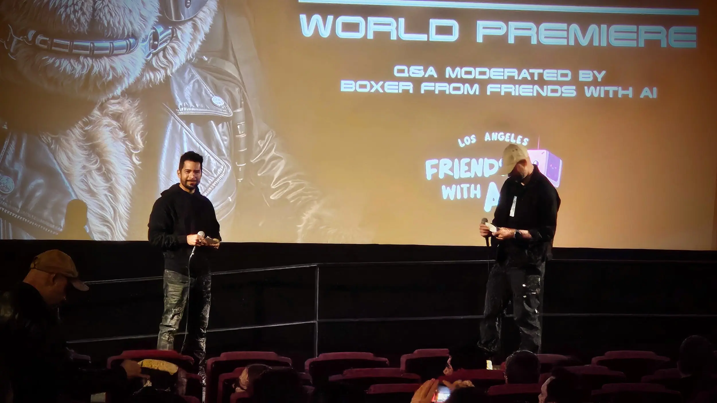 Dim theater with a few people seated and a bright screen showing an end card.
